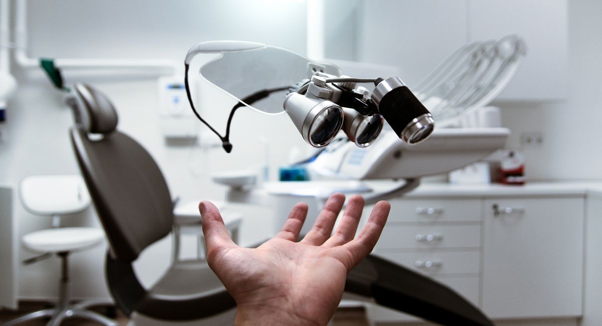 Consultorio dental con sillón y lupas de aumento clínicas